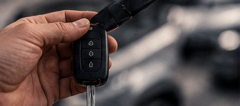 A hand holding out a car key