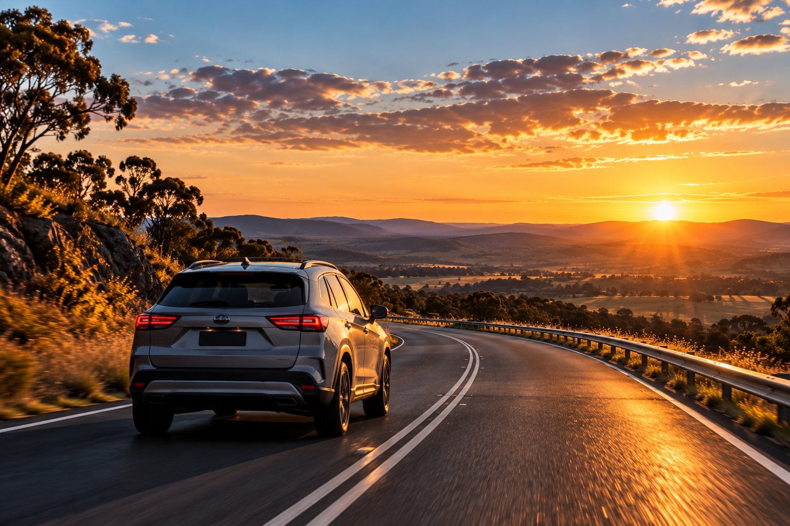 A car driving a winding country road at sunset