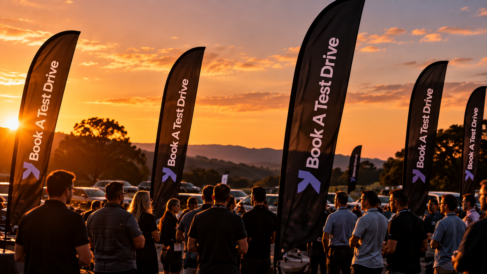 Automotive people gathered at an outdoor event at sunset
